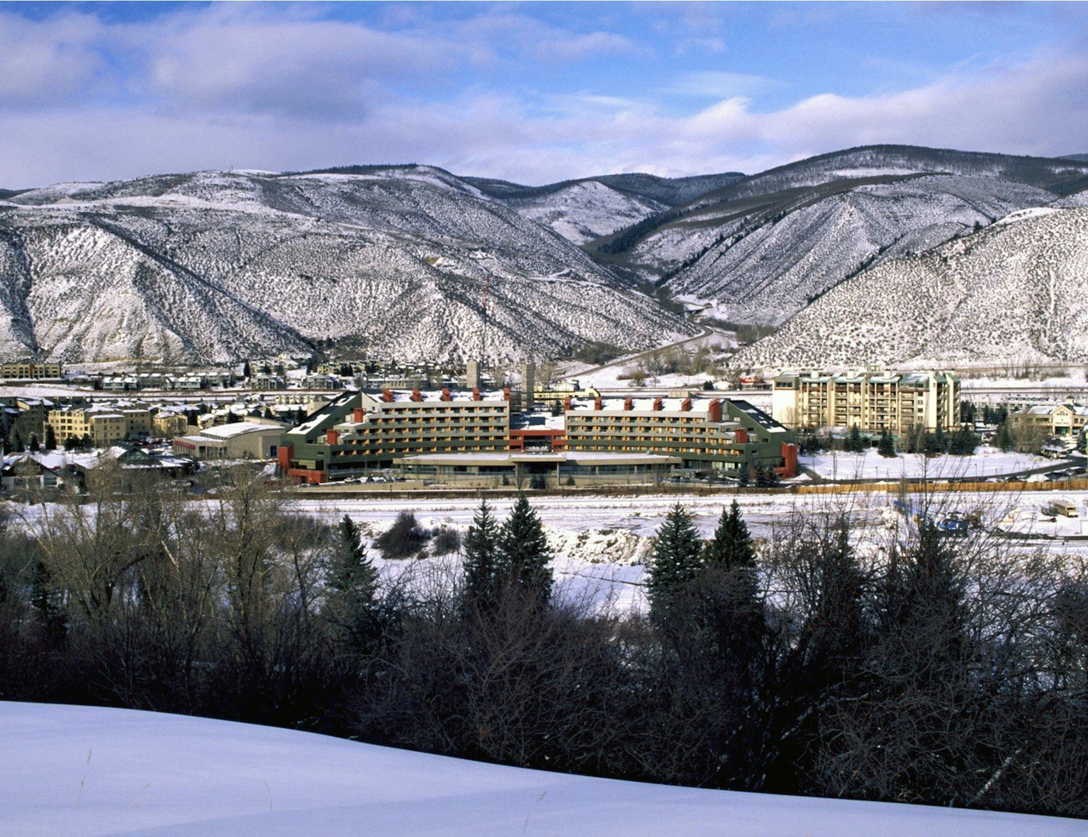 Winter view of Avon, Colorado at the entrance to Beaver Creek Resort, with snow-covered mountains and town buildings in the Vail Valley.