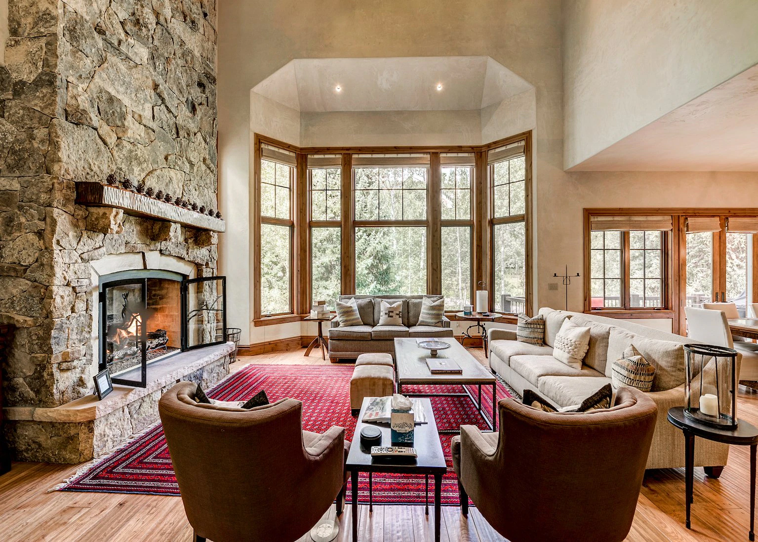 Luxurious lounge of a home rental in Beaver Creek with fireplace and large windows.