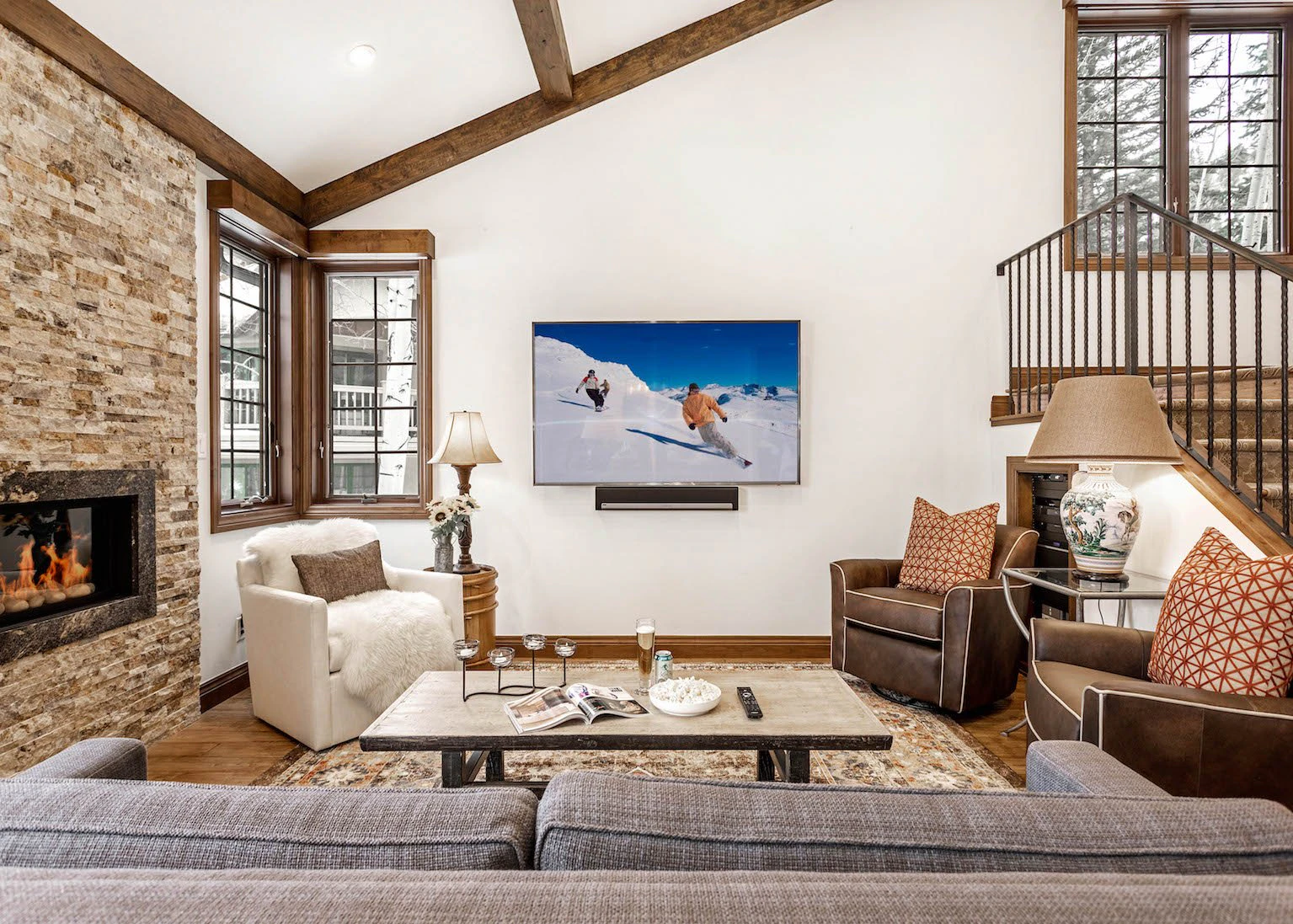 Lounge with couches, coffee table and fireplace in a beaver creek cabin available for rental.