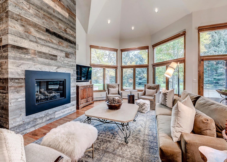 Luxurious lounge of a home rental in Beaver Creek with fireplace and large windows.