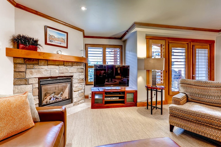 Vail condo rental option lounge with couches, tv, and fireplace.