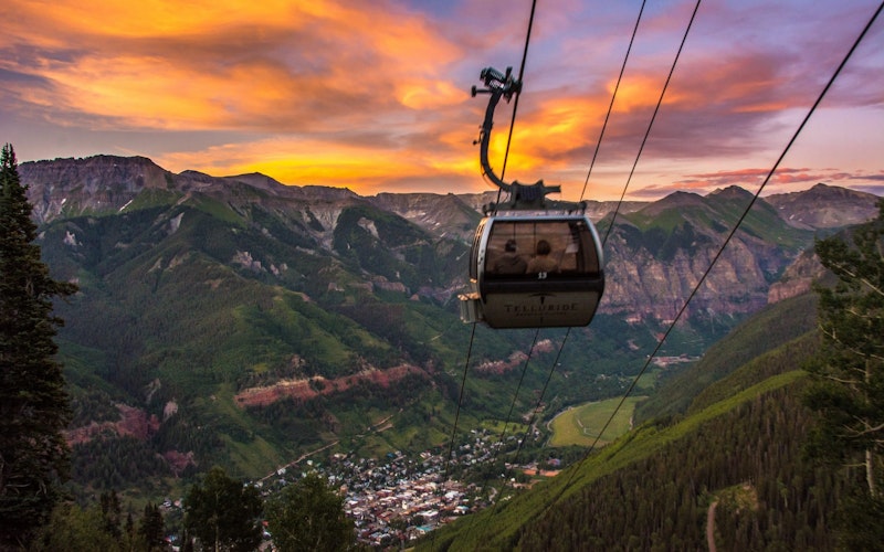 A gondola looking down over Telluride with a beautiful sunset in the background.