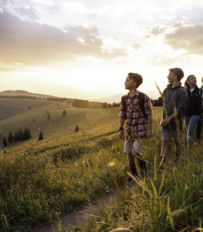 Family hike through the mountains at sunset in Vail, CO.