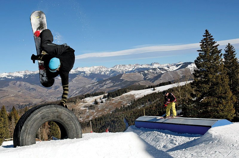A snowboarder catching air off a jump in a Beaver Creek terrain park