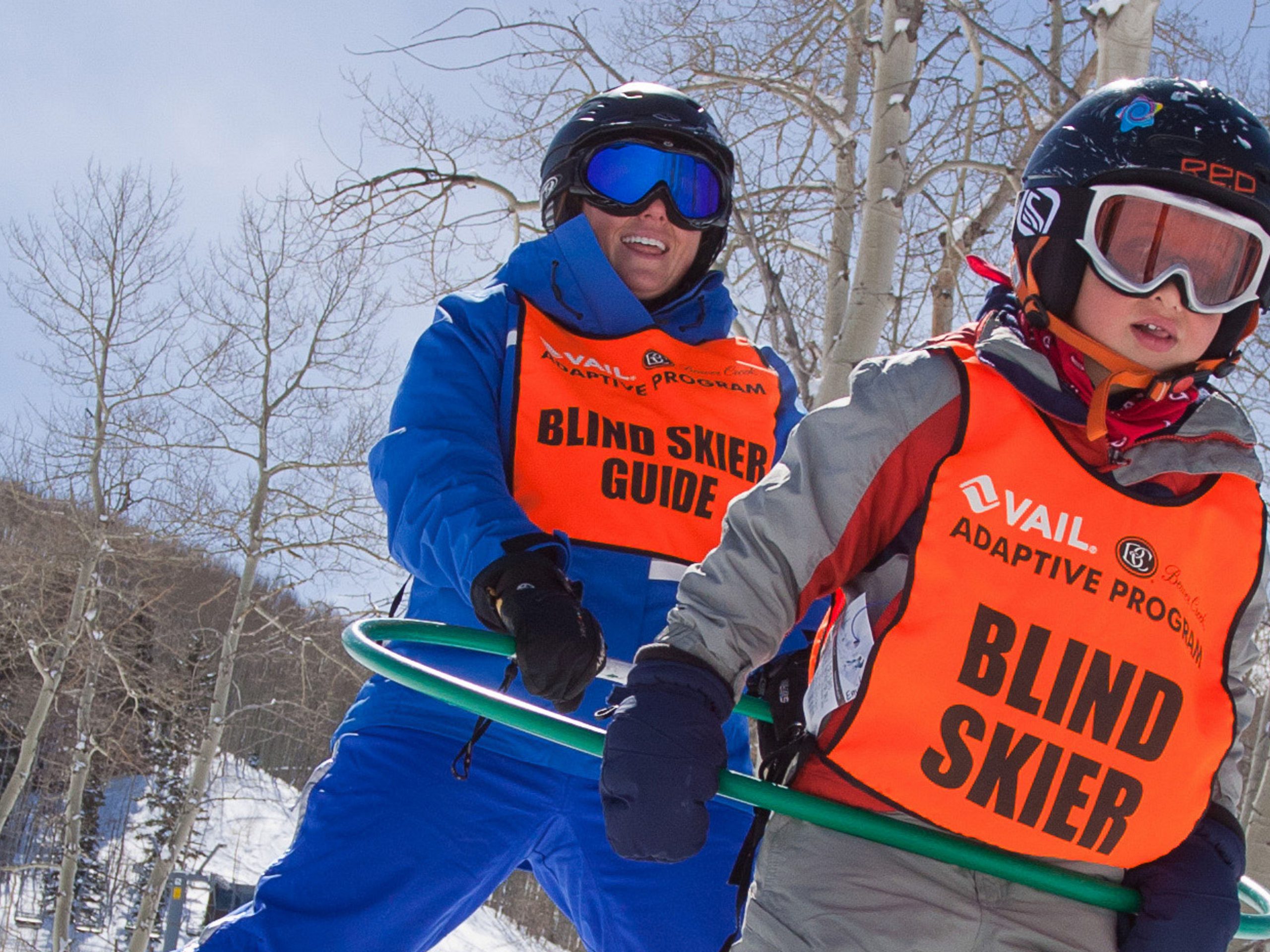 An adaptive skier and specialist instructor skiing together on the slopes at Beaver Creek