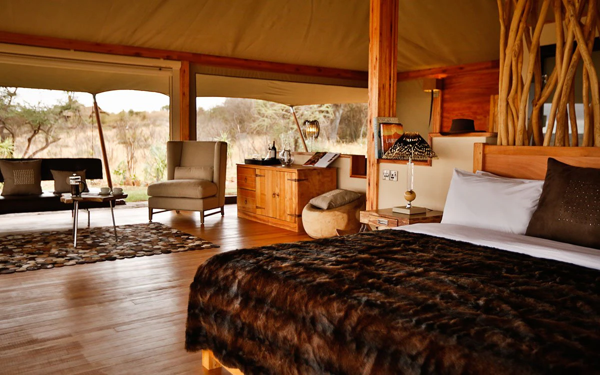 A wide angle view of the inside of the double tent at Loisaba Tented Camp showing the double bed and living area
