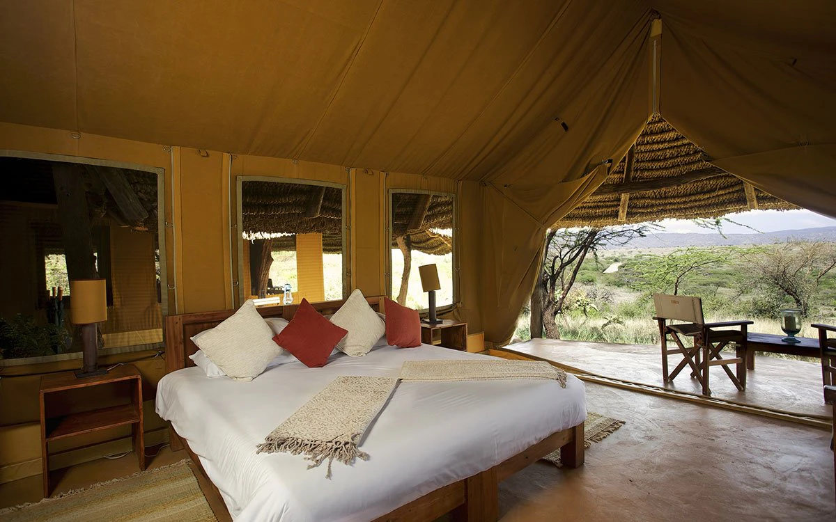 A freshly made double bed inside the family tent at Lewa