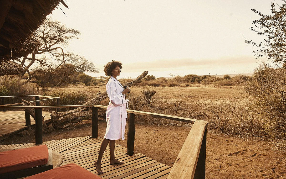 A guest steps out to survey the beautiful view from her private deck at Tawi Lodge
