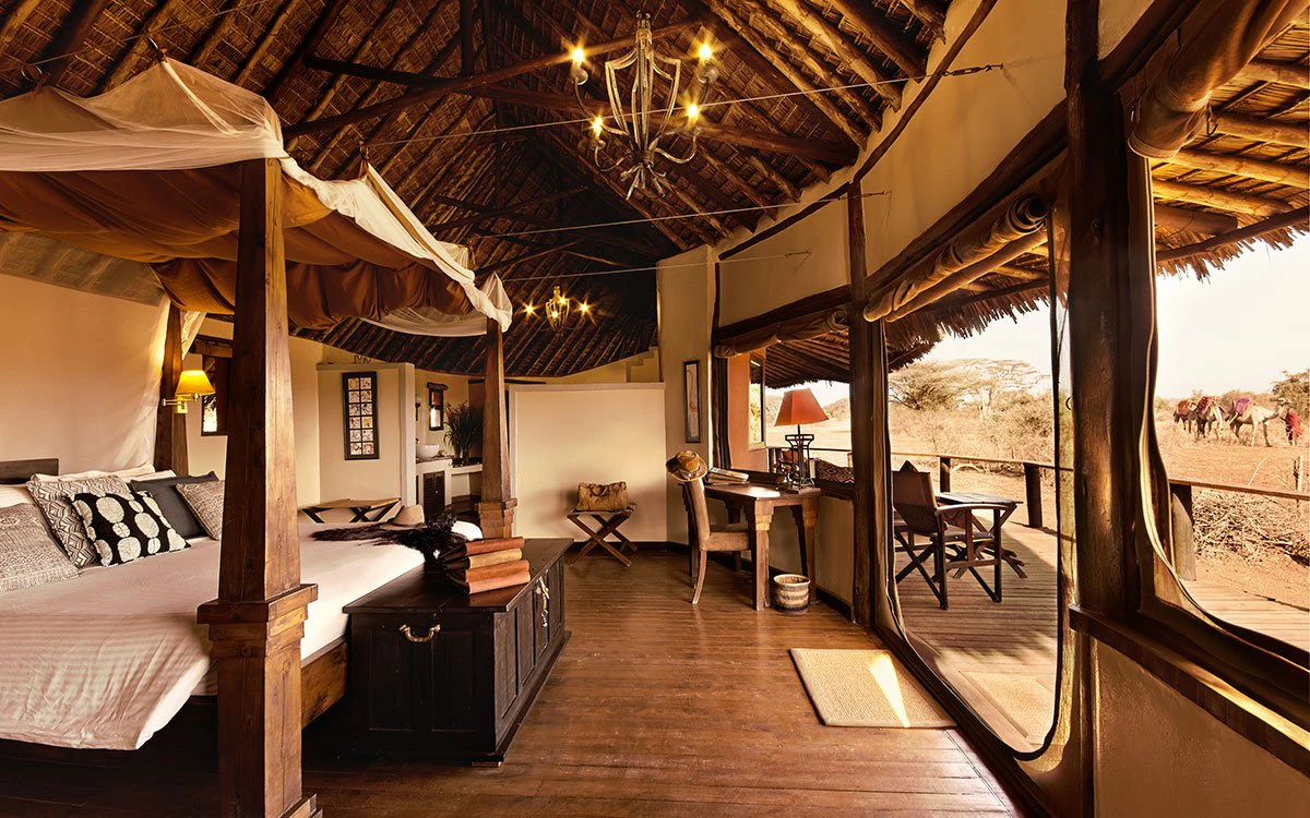 Wide angle view of both the inside and outside of a luxury bedroom at Tawi Lodge