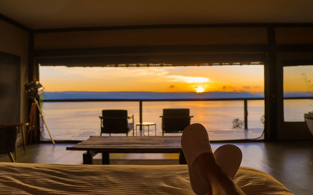 View from inside the bedroom at The Cliff showing the private deck during a radiant sunset