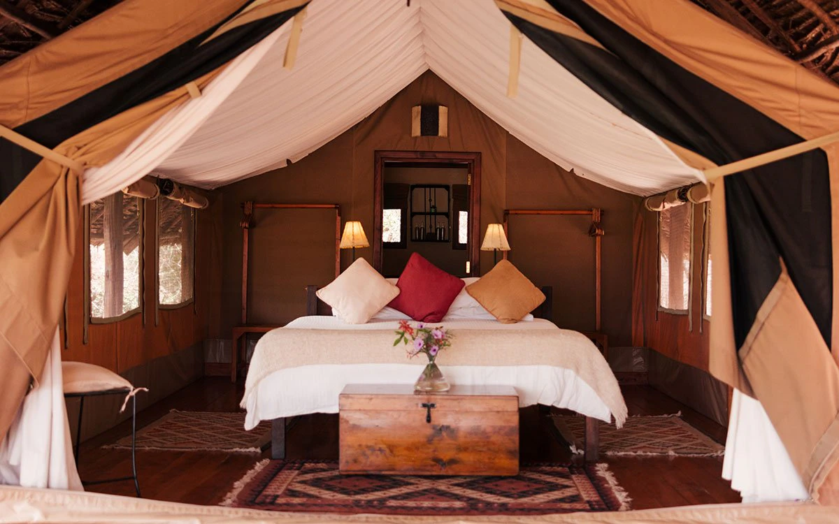 Interior view of a luxury bedroom in one of the tents at Tortilis Camp