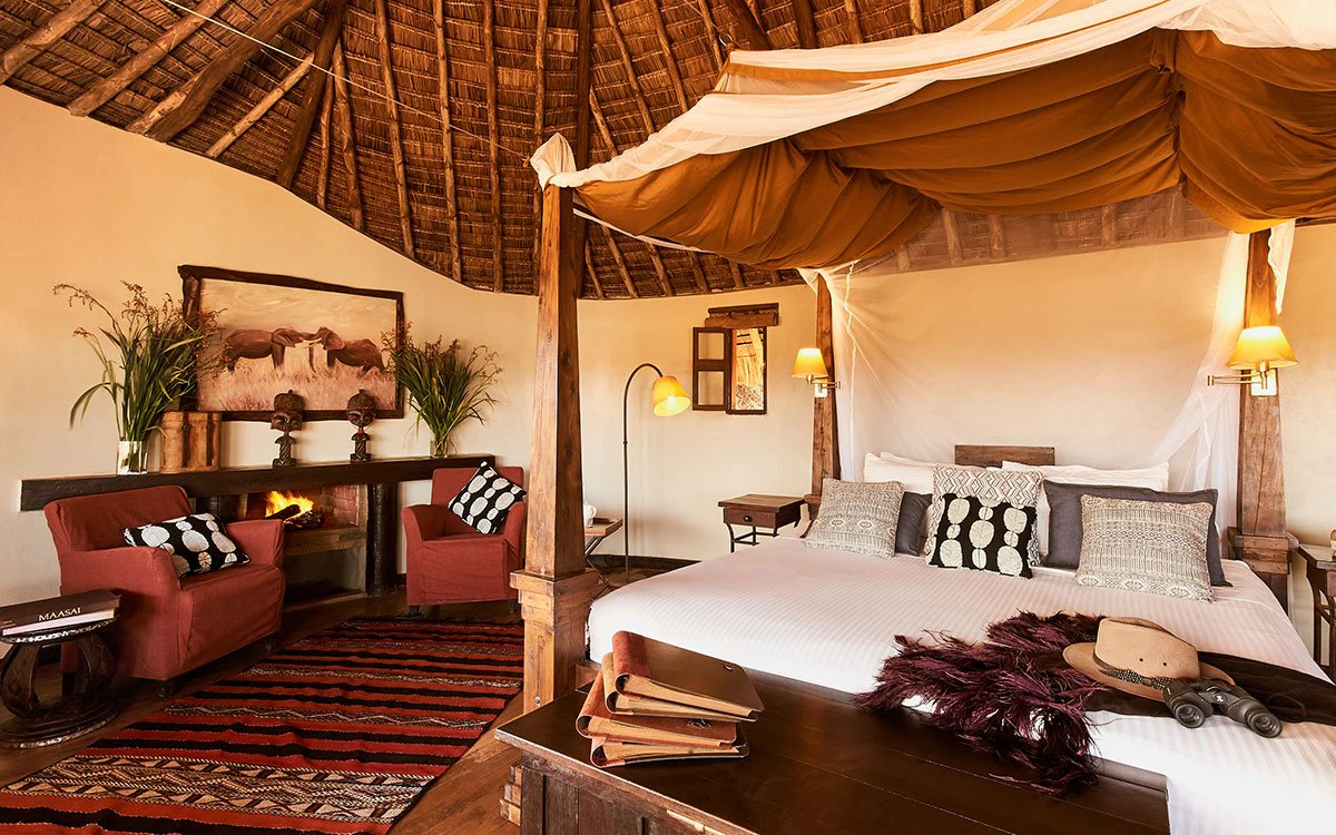 Interior view of a luxurious bedroom at Tawi Lodge where a bed and living area can be seen