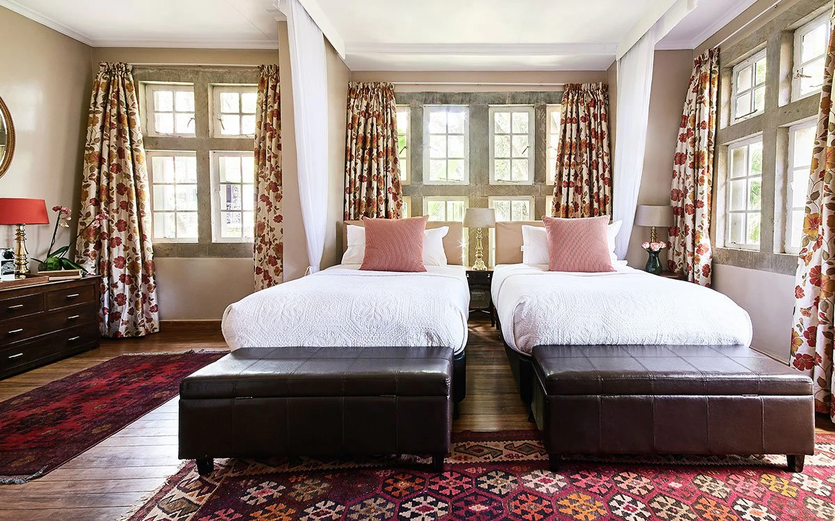 A twin bedroom suite at Giraffe Manor with both beds on display