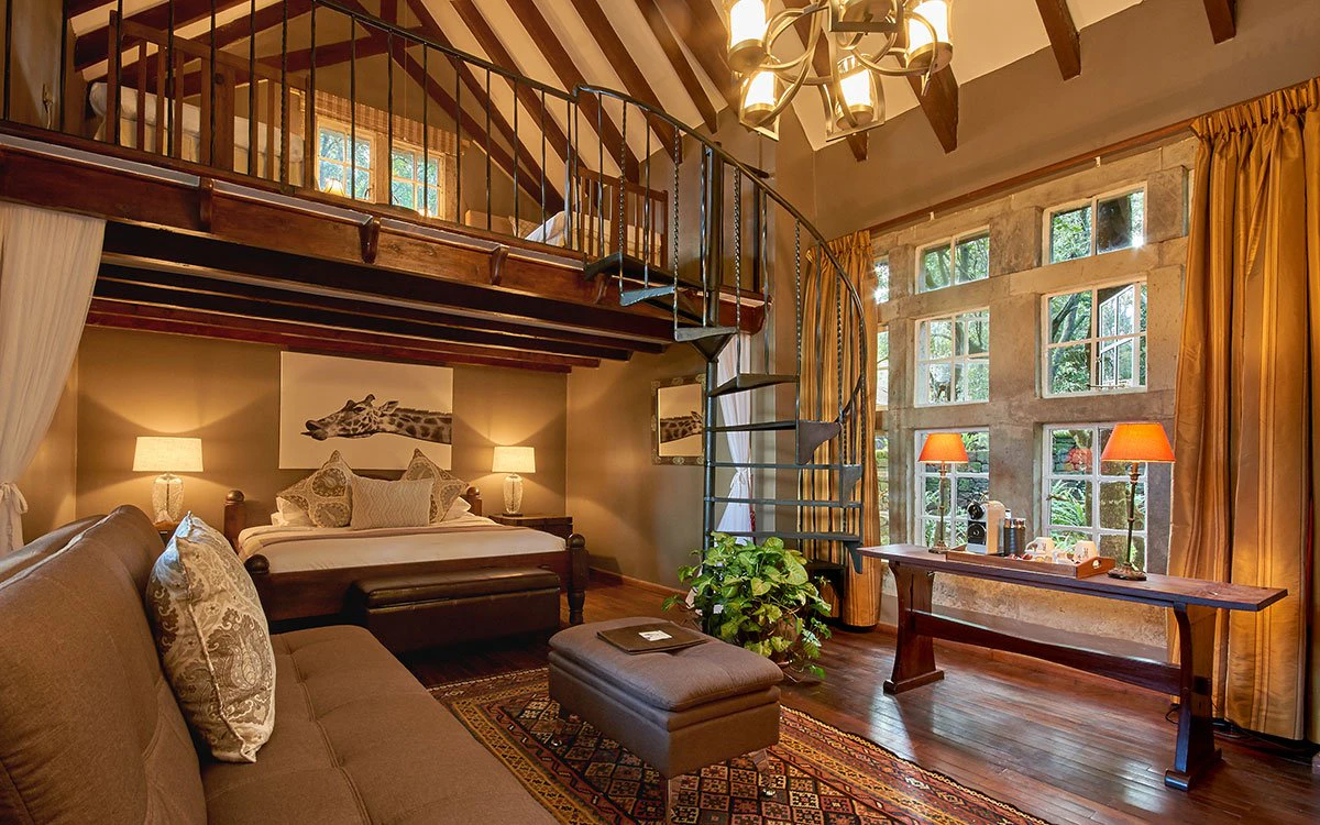 The luxurious Finch Hatton suite at Giraffe Manor showing the living area, spiral staircase and mezzanine level