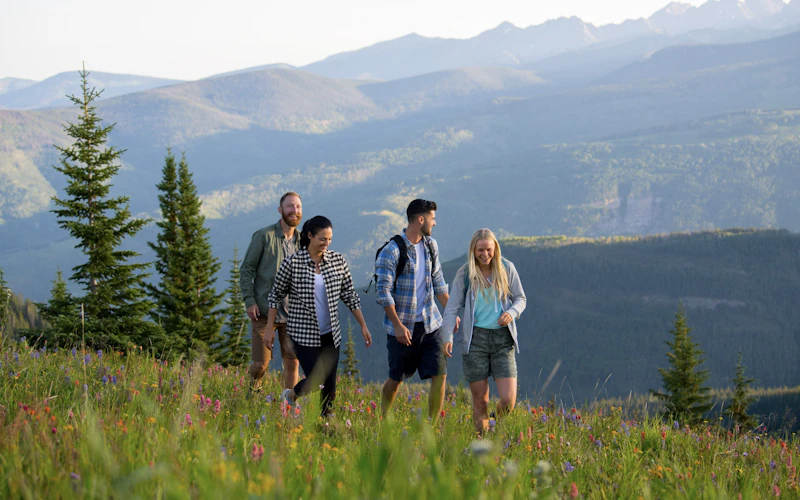 A happy family hiking in the beautiful mountain landscape of Vail Resort during the summer season