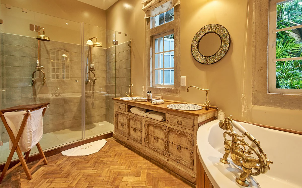 A luxury en suite bathroom at Giraffe Manor showing the bath, shower and double sink
