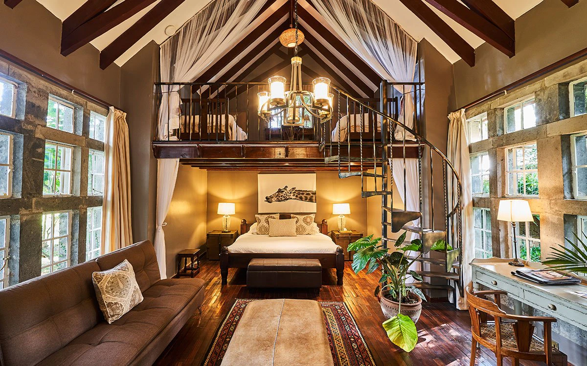 Wide angle image of a luxury suite at Giraffe Manor with the living room, bedroom and mezzanine on display