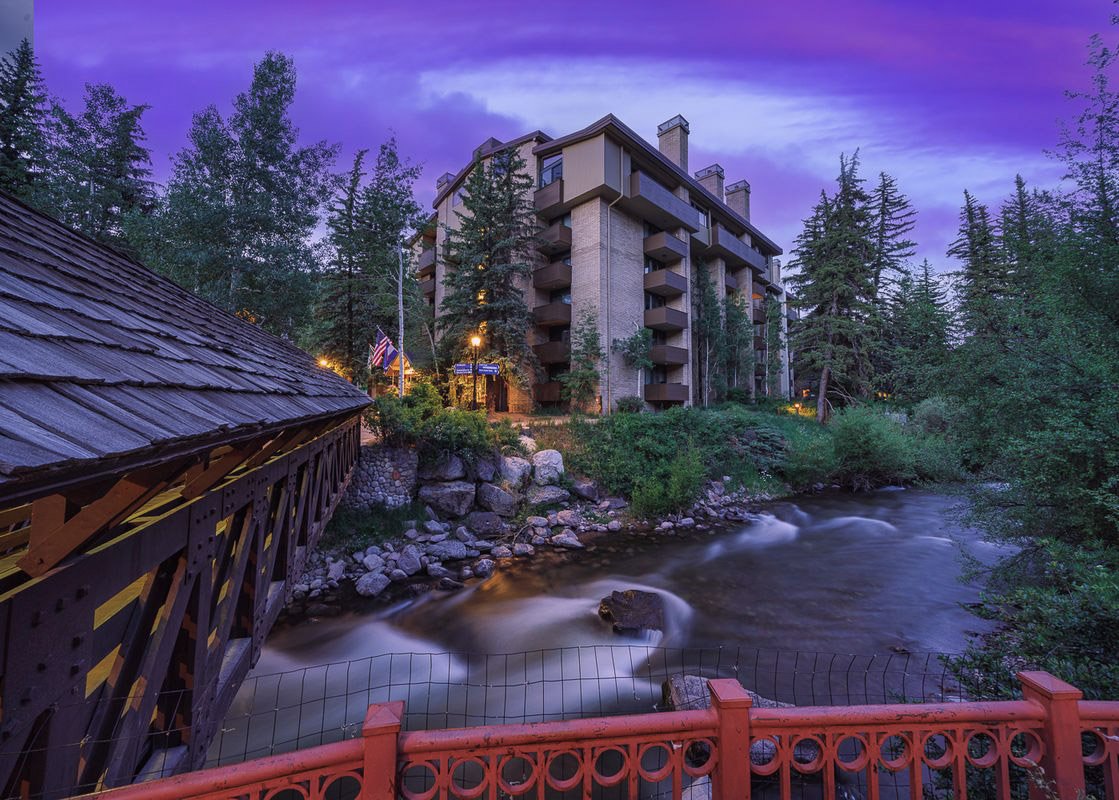 Picturesque night view of Vail's Mountain Haus luxury rental beside a creek in Valleyside.