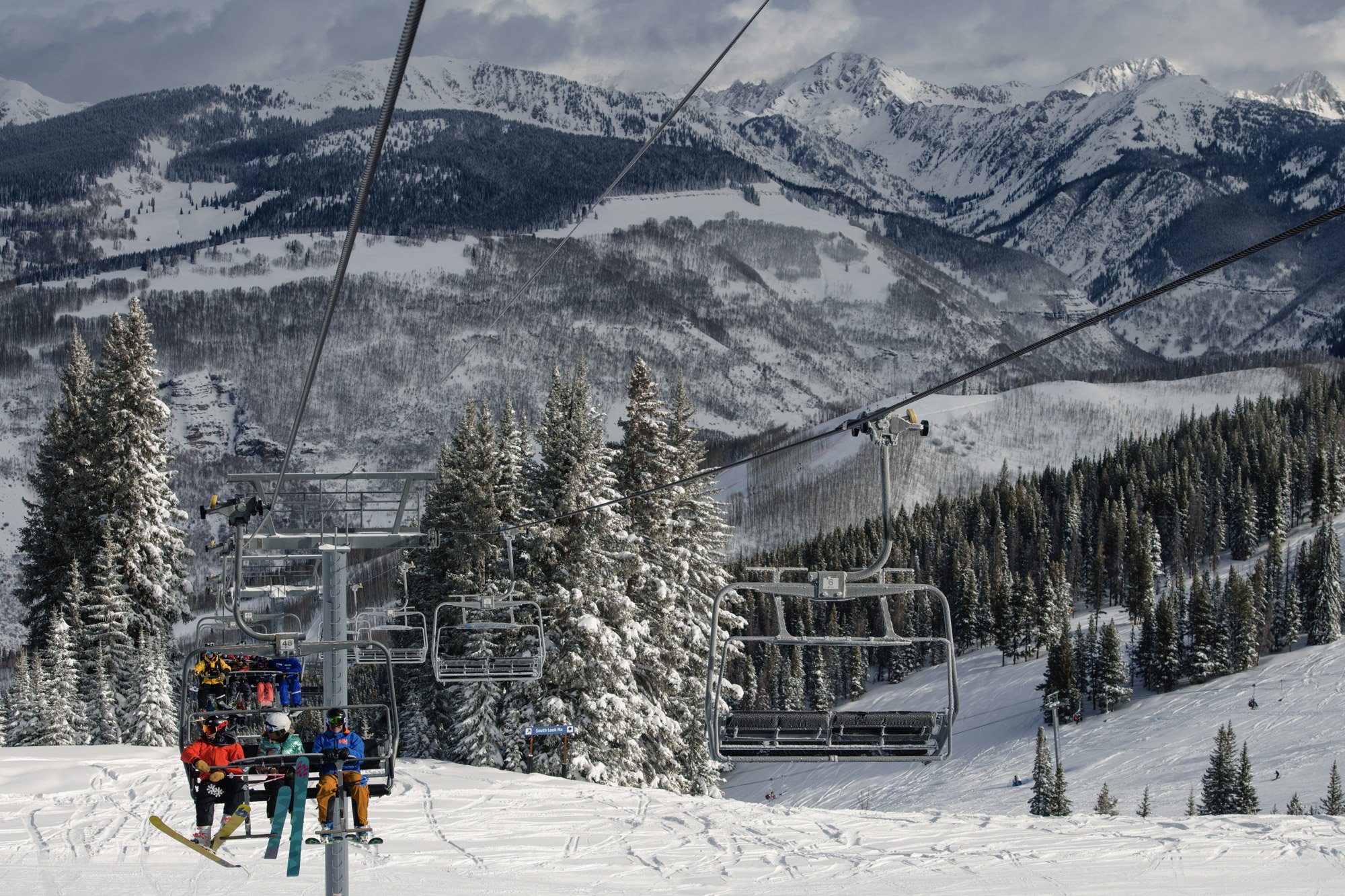 Enthusiastic skiers riding the chair lift in Vail, ready to explore the resort's vast skiing terrains