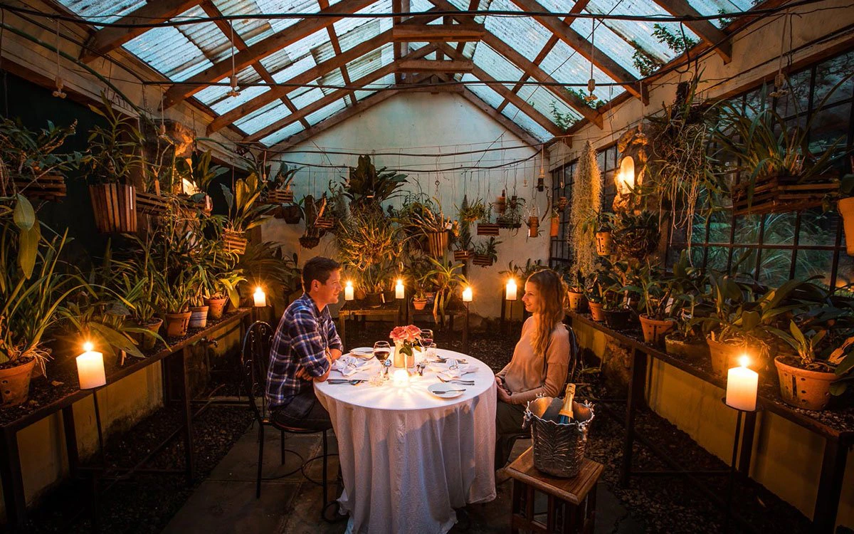 A couple enjoy a romantic, candlelit dinner in the Orchid House at Giraffe Manor