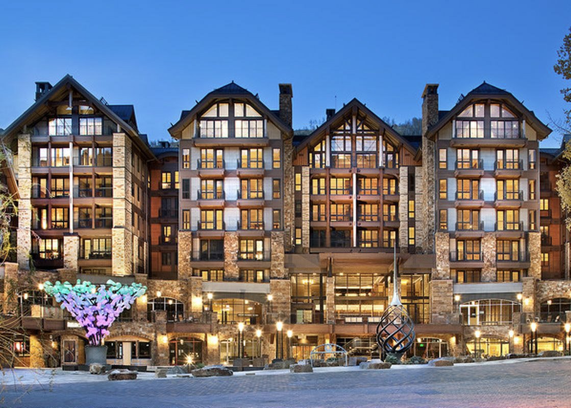 Sunset over Solaris Vail, a modern architectural masterpiece with a backdrop of Vail's iconic mountain range.