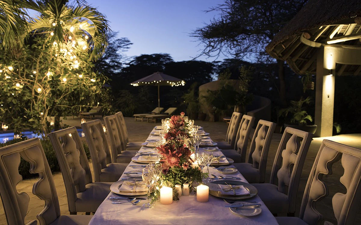 A large table set up for an al fresco dinner at Finch Hattons after sunset
