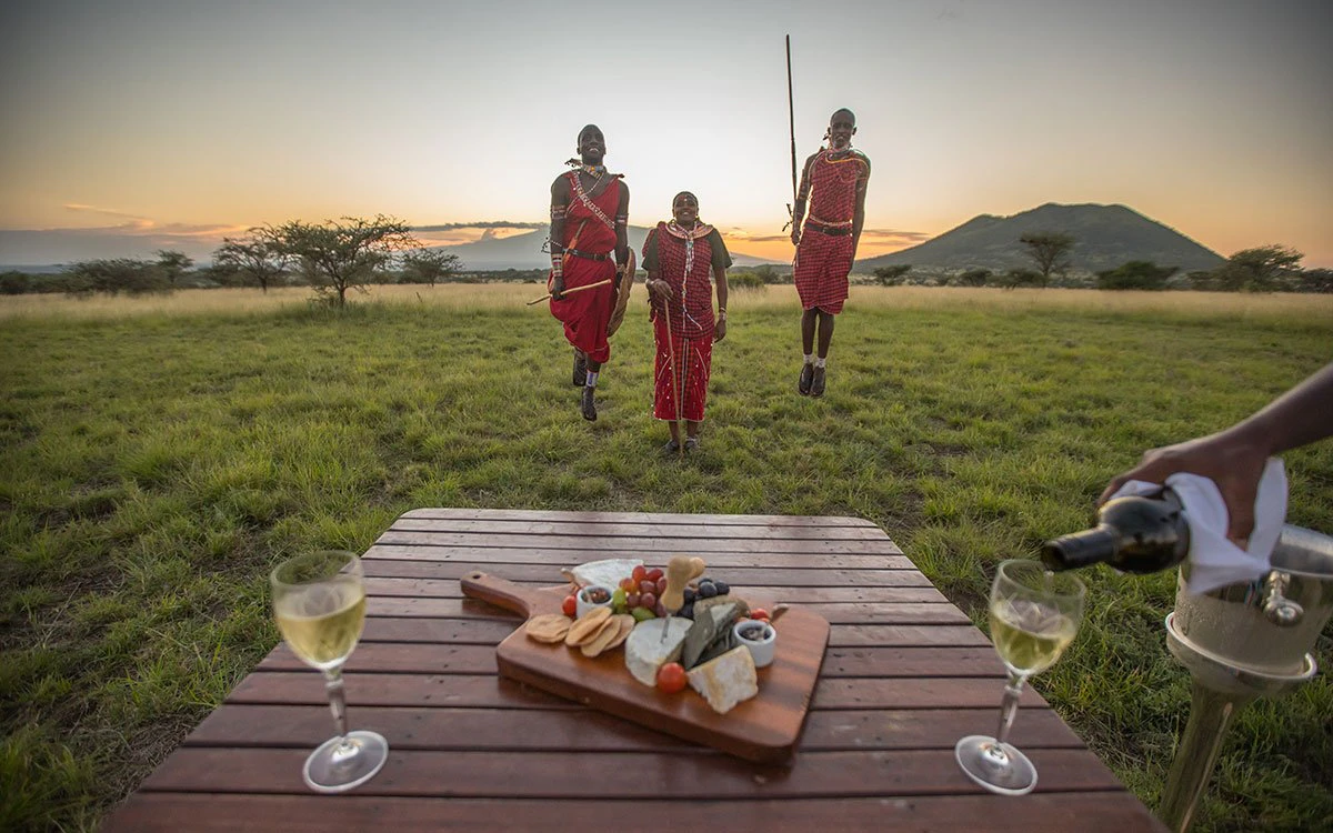 Three Maasai perform a traditional dance during sundowners
