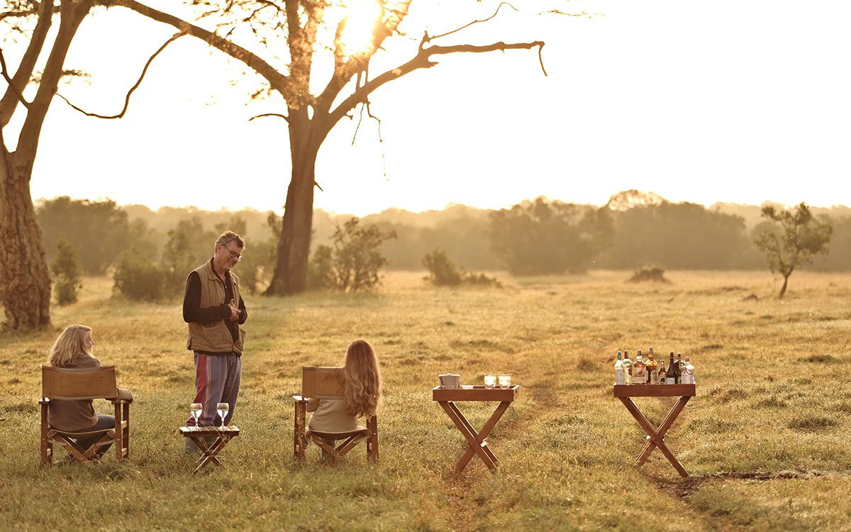 Guests at Ol Pejeta enjoy drinks outside as the sun begins to set