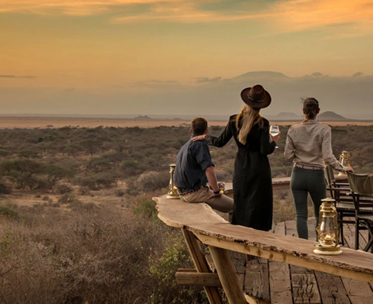 A group of guests enjoy an evening drink against a stunning dusk backdrop