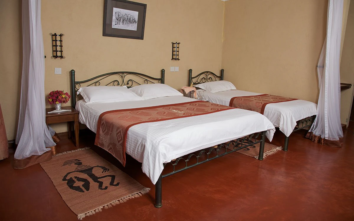 Interior view of a bedroom at Ashnil Aruba with a double and single bed in view