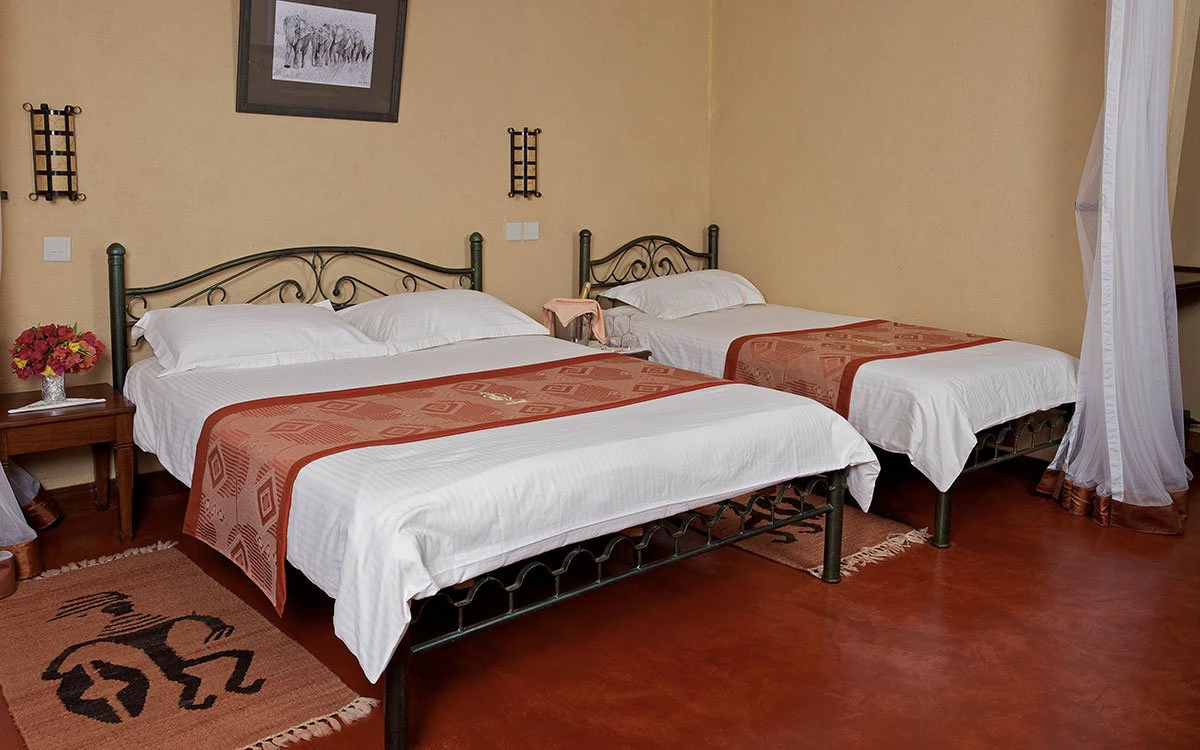 Interior view of a bedroom at Ashnil Aruba with a double and single bed in view