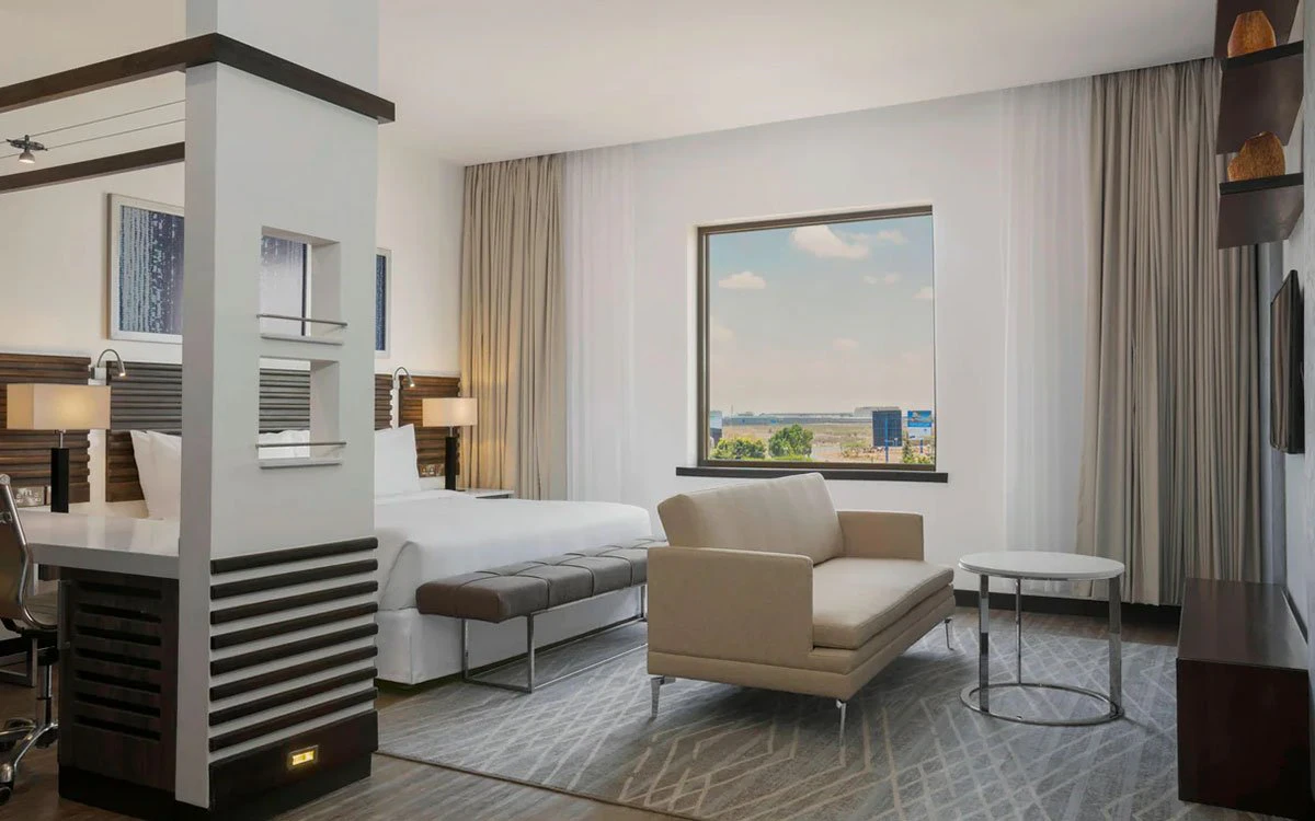 Interior view of a deluxe room at Four Points by Sheraton with the bed and sofa in view