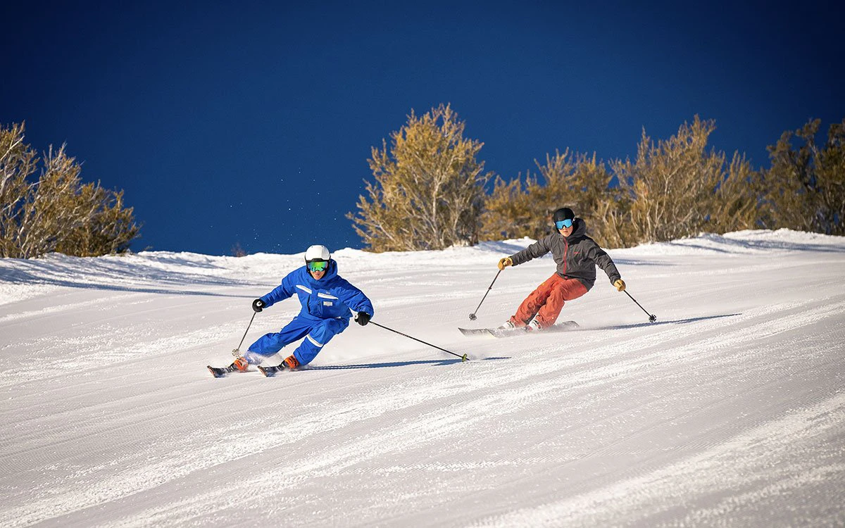 A ski instructor at Park City glides down the slopes with his student behind him.