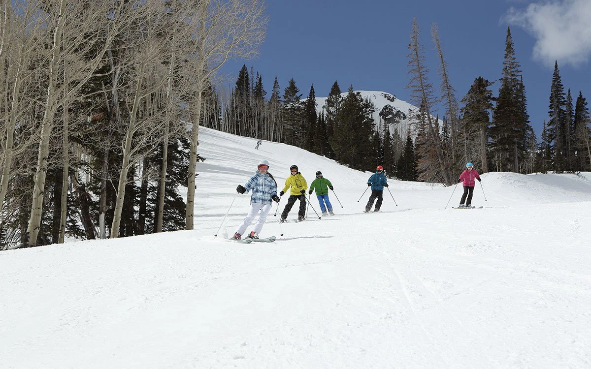 A group of skiers enjoy the first run of opening day at Park City Resort.