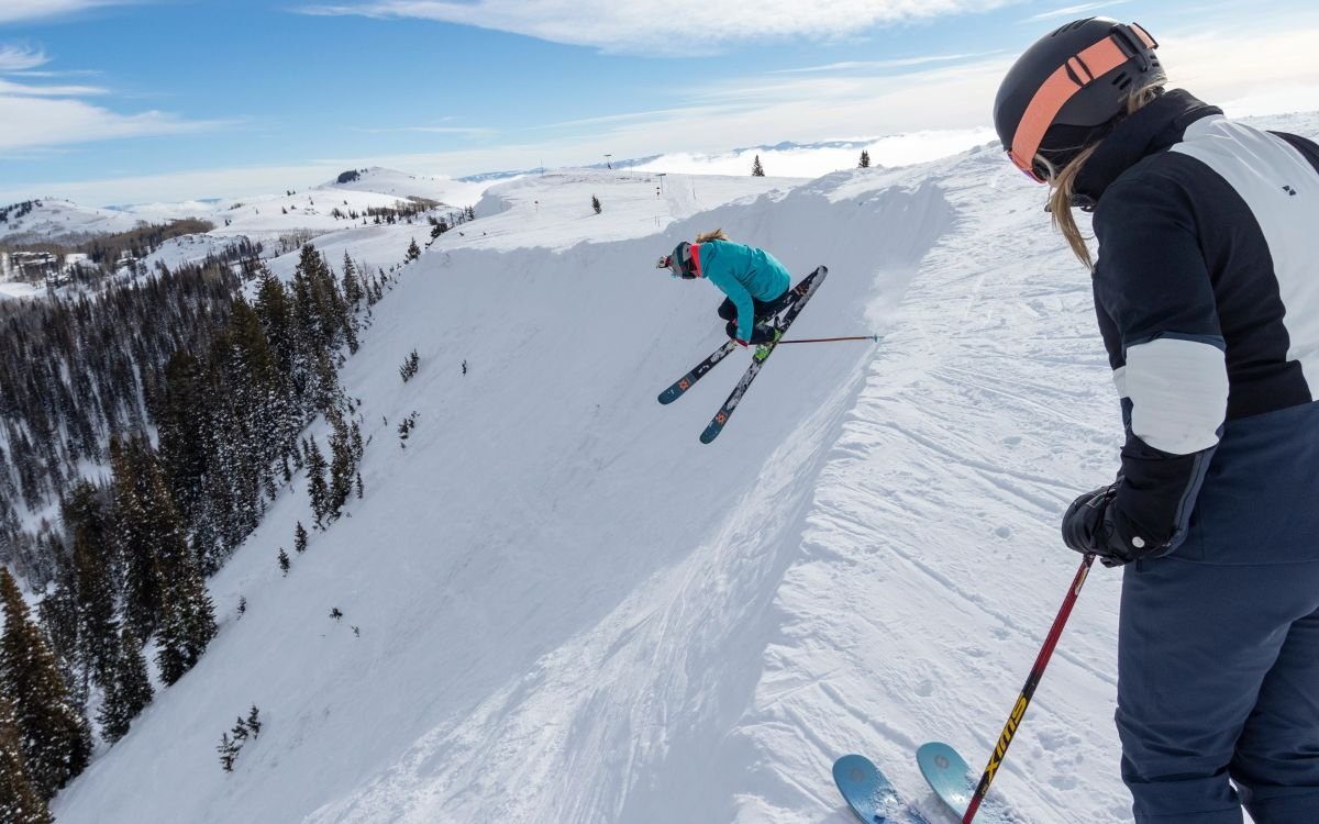 A pair of experienced skiers enjoy their day out on the mountains having used their ski pass.