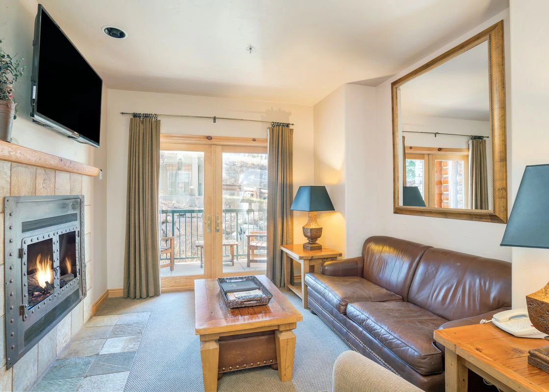 The living room inside one of the condos at Mountain Lodge in Telluride with a cozy fire on the go.