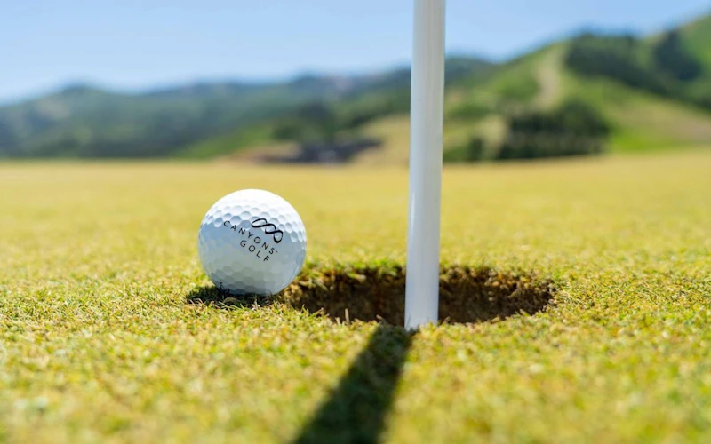 A golf ball rests on the edge of the hole at Canyons Golf. A golf ball rests on the edge of the hole at Canyons Golf.