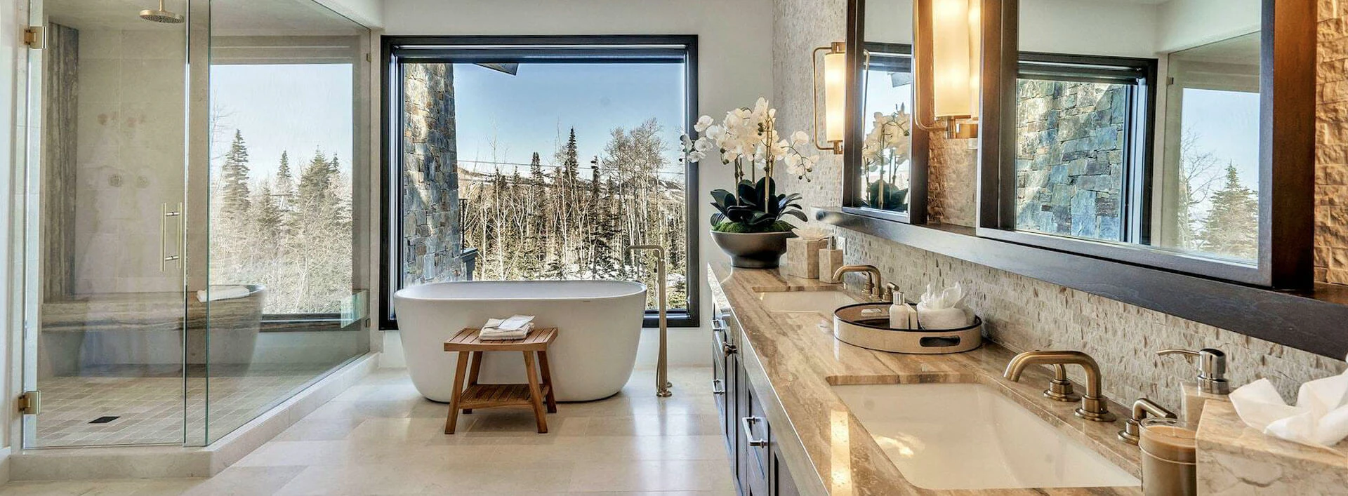 Spa-style bathroom in The Red Cloud, a Deer Valley luxury rental, featuring a freestanding tub and forest views through floor-to-ceiling windows. Spa-style bathroom in The Red Cloud, a Deer Valley luxury rental, featuring a freestanding tub and forest views through floor-to-ceiling windows.