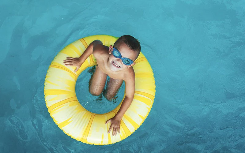 Child floating in a pool with sunglasses at a Deer Valley luxury rental offering family and pet-friendly services. Child floating in a pool with sunglasses at a Deer Valley luxury rental offering family and pet-friendly services.