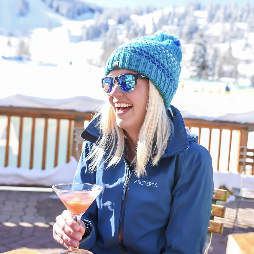 Guest enjoying après-ski cocktail on the deck of a Deer Valley luxury rental with snowy slopes in the background. Guest enjoying après-ski cocktail on the deck of a Deer Valley luxury rental with snowy slopes in the background.