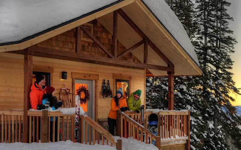 Family enjoying a cosy winter evening on the porch of a mountain cabin—part of Steamboat Luxury Rentals’ spacious, open-plan homes. Family enjoying a cosy winter evening on the porch of a mountain cabin—part of Steamboat Luxury Rentals’ spacious, open-plan homes.