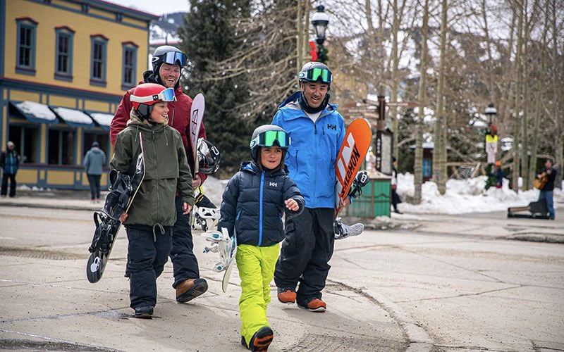 Family in ski gear walking through Breckenridge village, showing concierge services included with Breckenridge luxury rentals. Family in ski gear walking through Breckenridge village, showing concierge services included with Breckenridge luxury rentals.