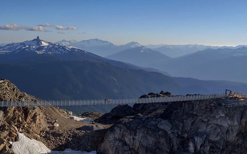 View of suspension bridge and alpine landscape in Whistler, showcasing outdoor experiences available with Whistler Luxury Rentals.
