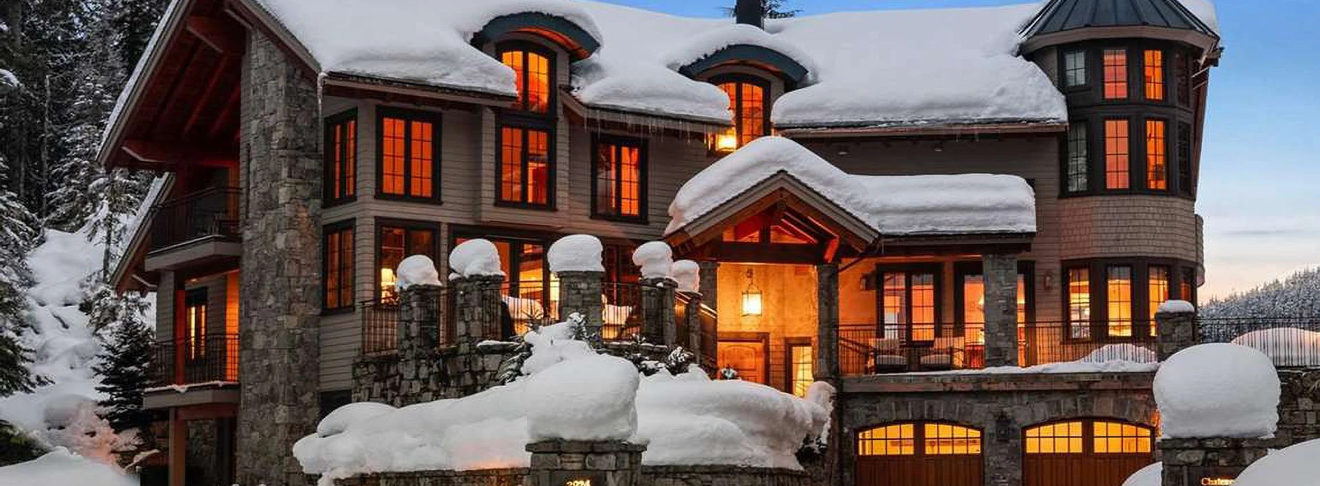 Chateau Mondeau, a snow-covered alpine estate in Whistler, glowing warmly at dusk—an exquisite example of Whistler Luxury Rentals.