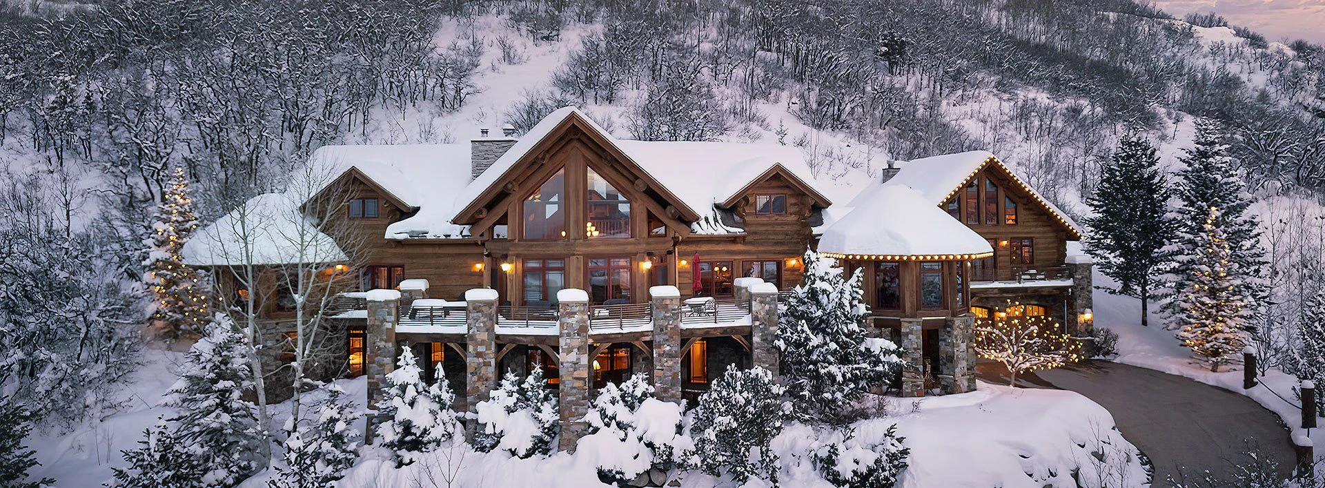 Exterior view of See Me Lodge in winter, a premier Steamboat Luxury Rental nestled in the snowy mountains of Colorado with twinkling lights and timber-frame architecture. Exterior view of See Me Lodge in winter, a premier Steamboat Luxury Rental nestled in the snowy mountains of Colorado with twinkling lights and timber-frame architecture.