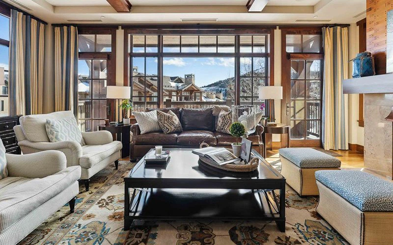 Living room at Flagstaff Lodge with large windows and mountain views, offering a refined Deer Valley ski-in/ski-out condo experience.