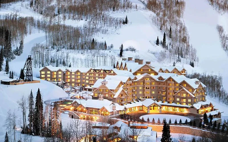 Montage Deer Valley resort illuminated against a snow-covered mountain backdrop, offering exclusive Deer Valley ski-in/ski-out access.