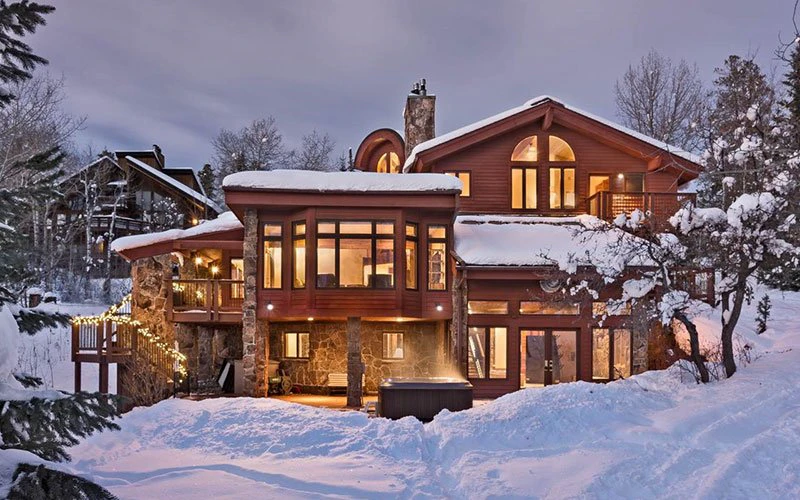 Trails Edge Lodge Steamboat Springs Ski-in/Ski-out luxury home with snow-covered exterior and lodge lighting.