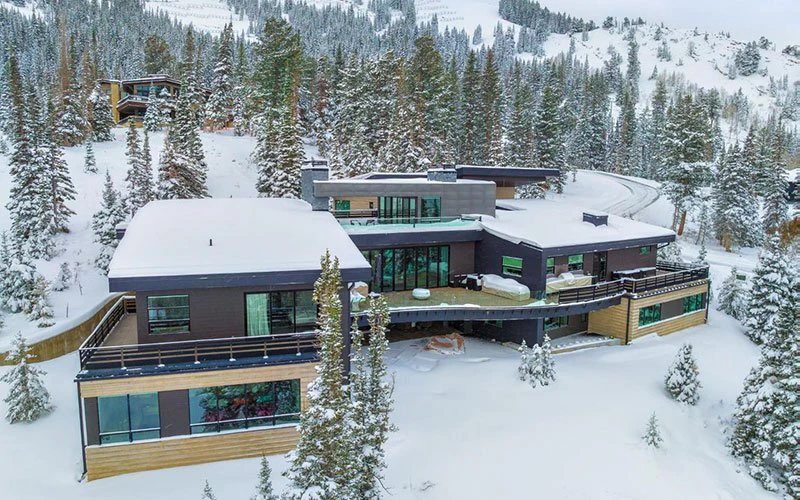 Aerial view of Ski Palace, a modern luxury Park City ski-in/ski-out estate with rooftop terraces and expansive snowy surroundings.
