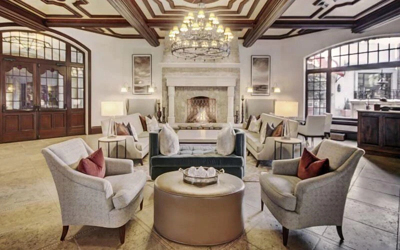 The Arrabelle Vail ski-in/ski-out hotel lounge with elegant seating area and stone fireplace near Eagle Bahn Gondola.